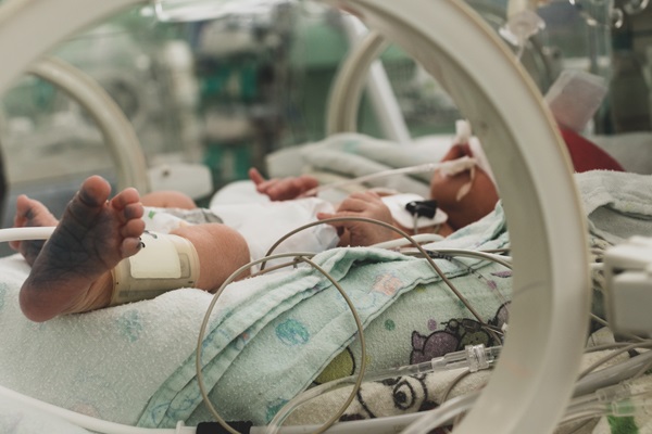 Incubator with a sick newborn baby at neonatal intensive care unit.